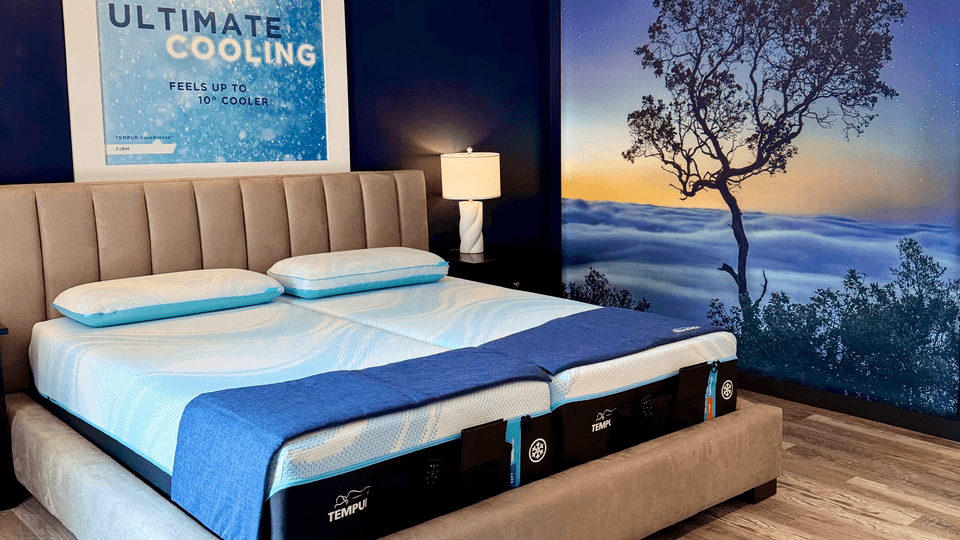 A Tempur-Pedic Retail Showroom Sleep Pod with a Scenic Background Showing Silhouetted Trees at Sunset