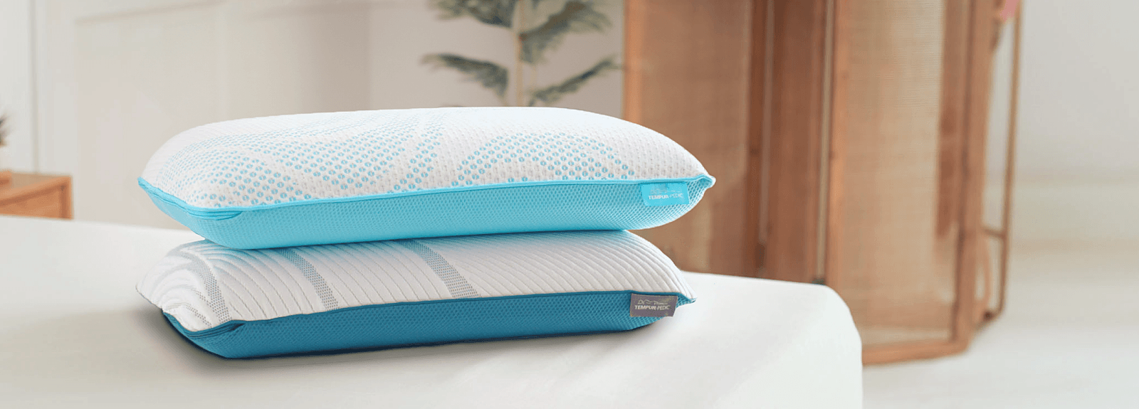 A stack of Breeze and Adapt pillows on a mattress