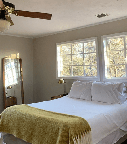 Casawilliamstx image of bedroom with white bedding, yellow blanket, and decorated room.png