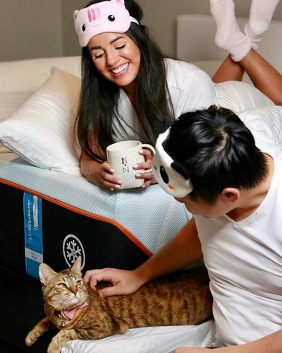 Man, woman and cat lounging around mattress smiling.JPG