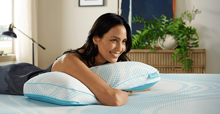 Woman hugging a Breeze pillow on a mattress