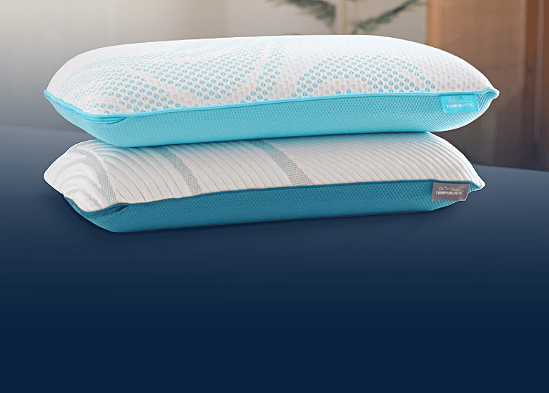 A stack of Breeze and Adapt pillows on a mattress