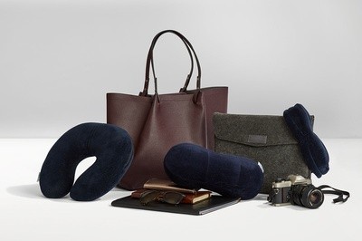 Travel bags with a neck pillow, sleep mask, camera, and journals