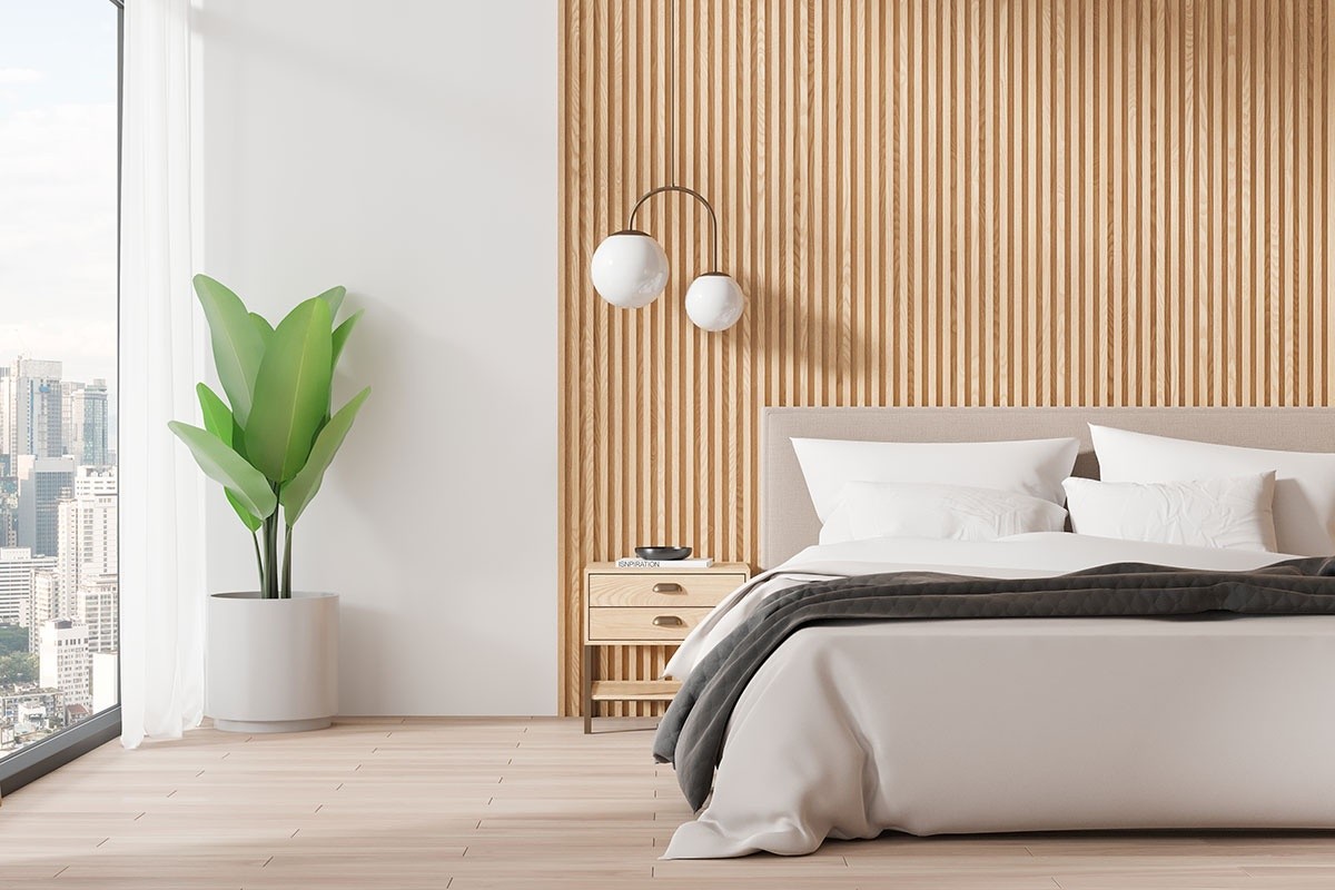 Minimalist styled room with made bed, plant, and city view