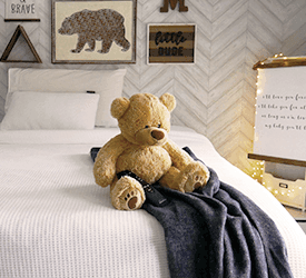 a teddy bear on a mattress in a kids room. Photo taken by @mygeorgiahouse