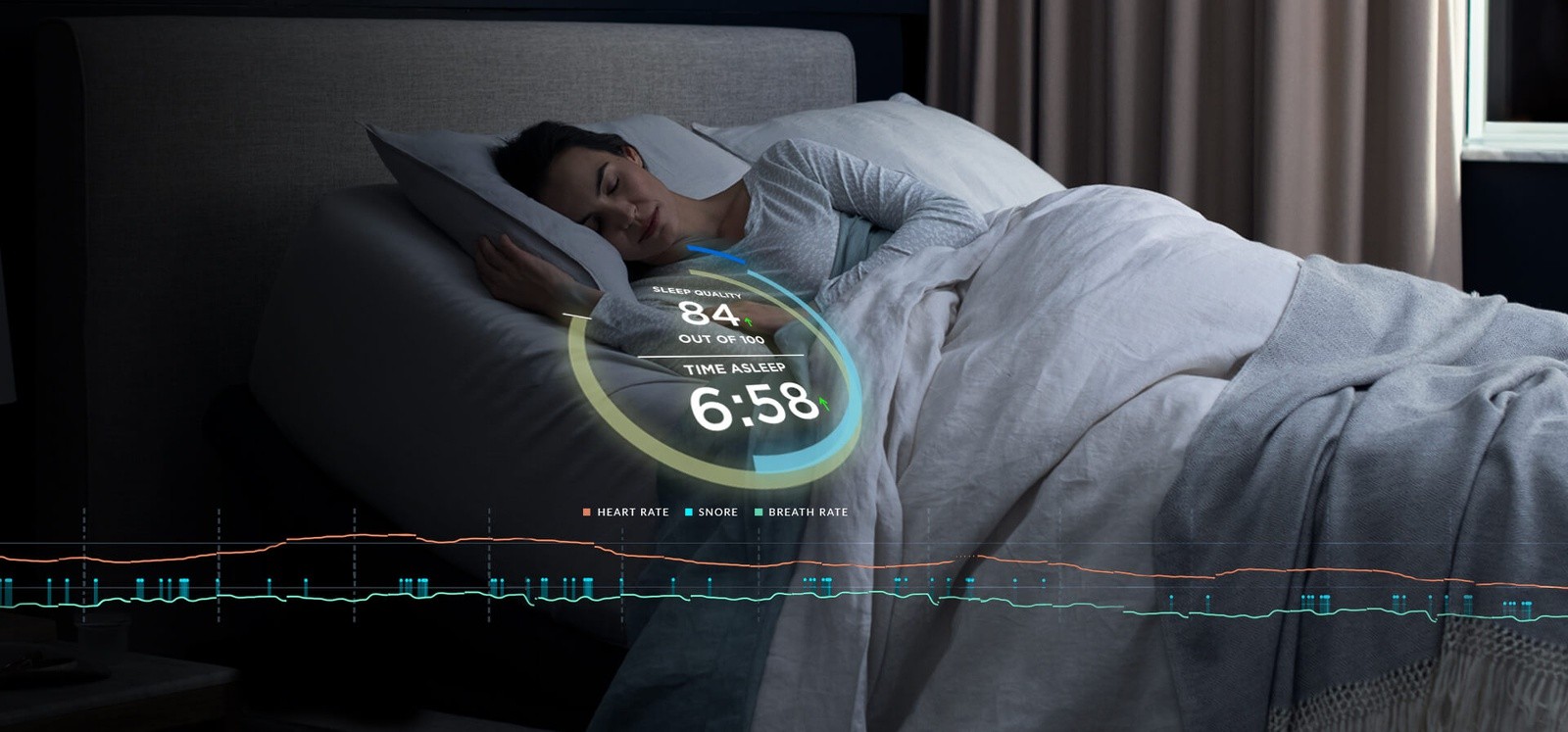 Woman sleeping with the Tempur-Ergo Smart Base monitoring her snoring, heart rate, and breath rate