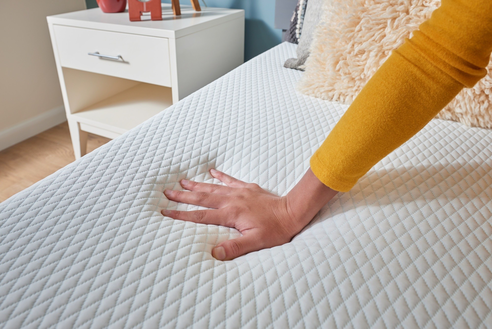 Women pressing hand on cooling topper