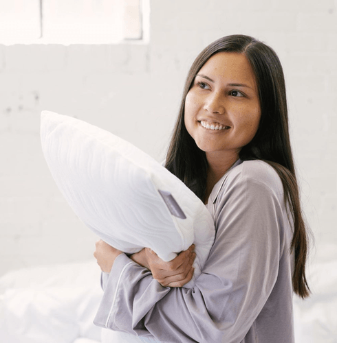 Woman Smiling and Hugging TempurPedic Pillow