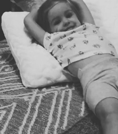 A little girl laying on a tempur-cloud pillow