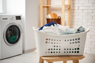 A Full Laundry Basket in Front of a Washing Machine