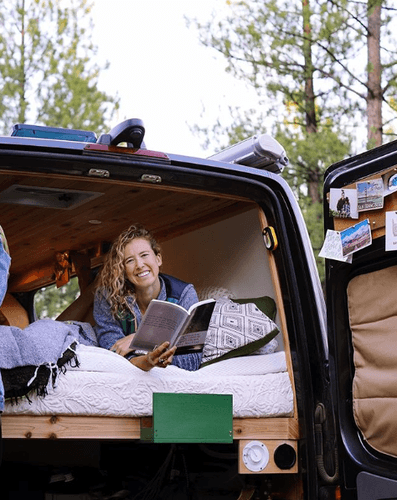 Woman Smiling in Trunk of Car on Mattress Topper