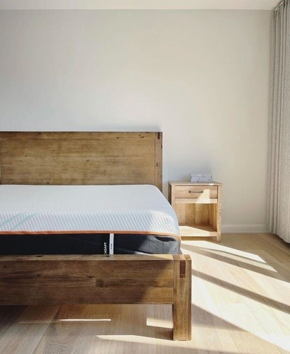 wood bedframe with a Tempur-Pedic ProAdapt Firm on it and a matching wood bedside table