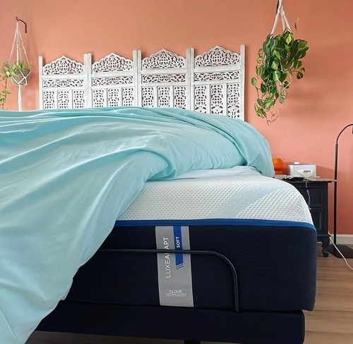 LuxeAdapt mattress with coral orange wall and white headboard behind the bed