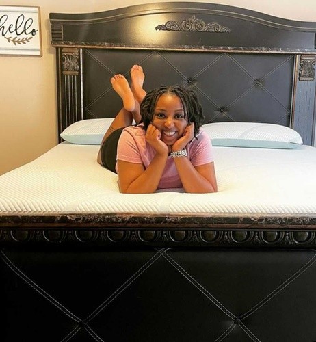 woman lying on stomach with head propped up while smiling on Tempur-Pedic mattress.jpg